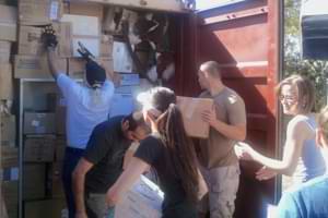 Volunteers Loading Donated Supplies Into Shipping Container