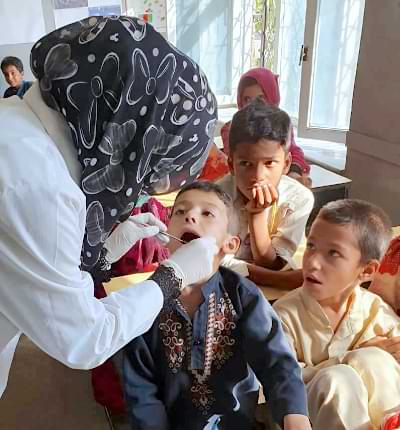 Saher Examining a Boy's Teeth