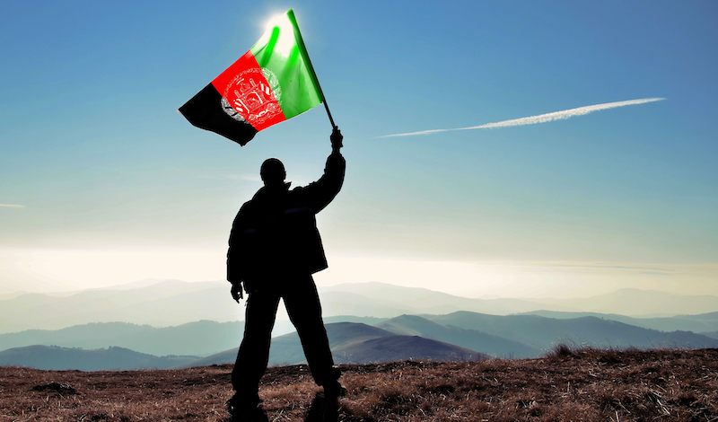 Man Waving Afghan Flag In the Sun