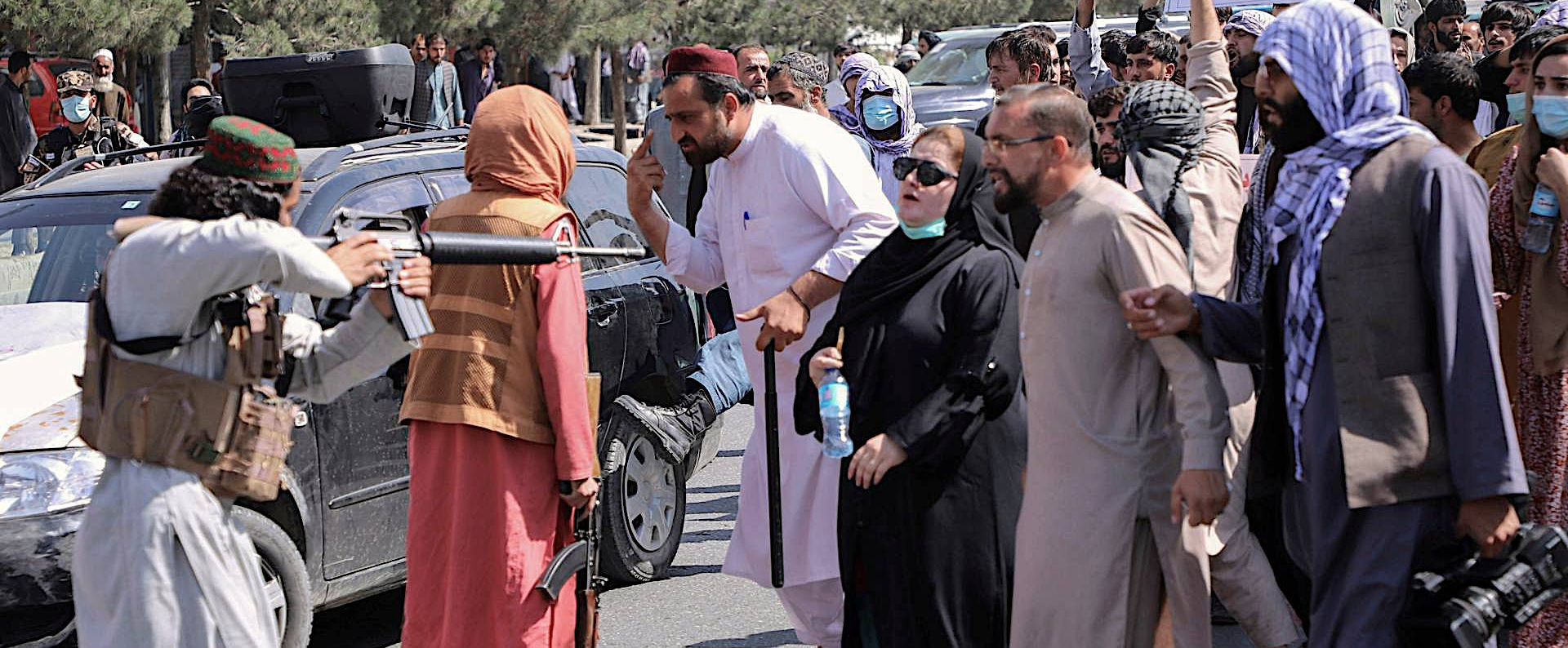 Taliban insurgent threatening to shoot a woman for not wearing a burka